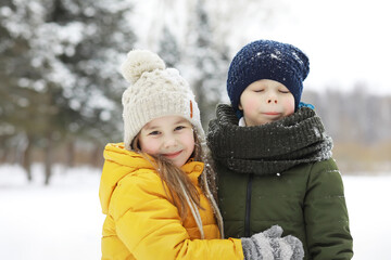 Happy family playing and laughing in winter outdoors in the snow. City park winter day.