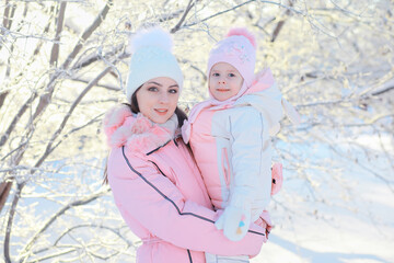 Family with children play snowy winter games in the park. Winter holidays and family vacation. Winter walk on the street on a sunny frosty day.