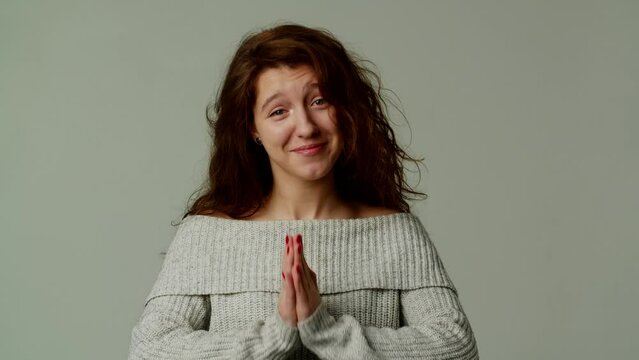 A pretty teenage girl asks her parents for money to buy fashionable clothes or jewelry. A young lady sincerely and heartily begs for forgiveness for mistake and wishes reconciliation. Gesture I beg