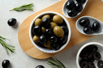 Olives in a white bowl on a wooden board