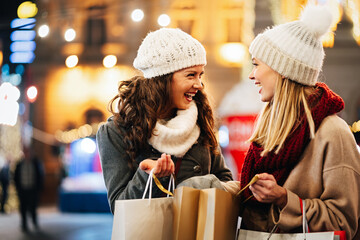 Happy women friends having fun and shopping at Christmas. Sale xmas people happiness concept