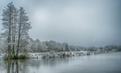 Frozen lake in northern German countryside after snowfall in winter