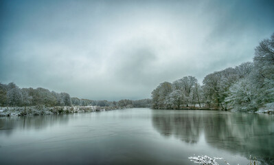 Frozen lake in northern German countryside after snowfall in winter
