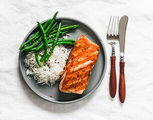 Delicious healthy lunch - grilled salmon, basmati rice and green string beans on a light background, top view