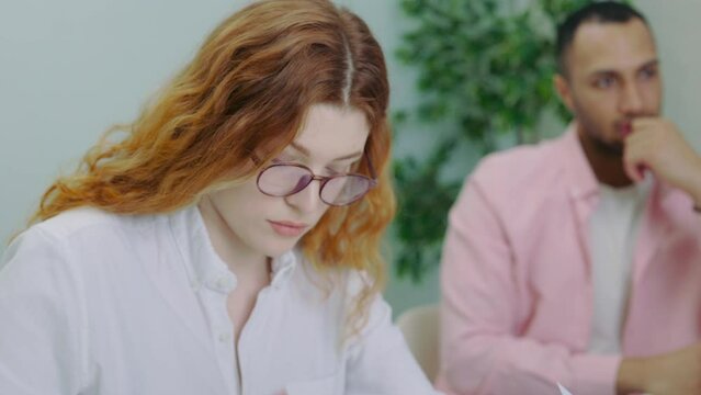 Attractive Woman Team Member Noting Information on the Business Meeting in Office.