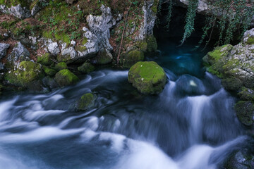 river flows out of a cave at Gollinger Waterfall