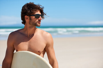 Man tinking, surf and travel with sunglasses by the beach and sea for fitness and water sport with mockup space. Confidence, male person and surfboard for workout and training by ocean with freedom