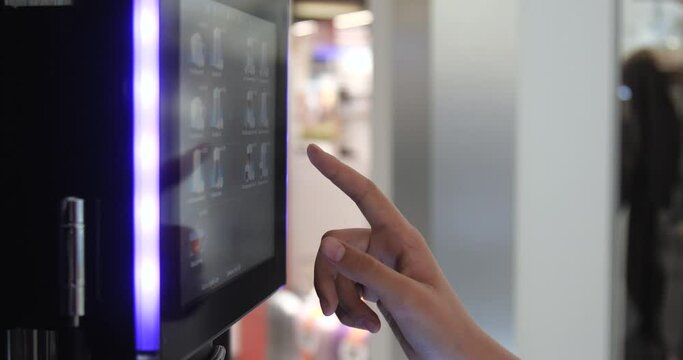Close up of  human hand choosing coffee drink using touchscreen of smart coffee machine