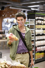 Portrait, man and customer shopping for apples, groceries and fresh goods in supermarket. Happy consumer, retail convenience store and grocery mall to purchase fruits, healthy vegan food and product