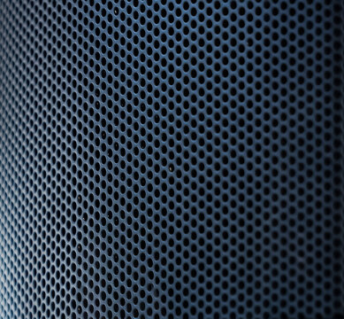 The close up photo of the modern black speaker and the metallic stand on a blurry background.