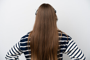 Telemarketer caucasian woman working with a headset isolated on white background in back position