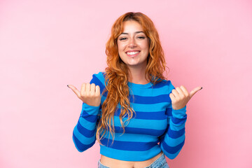 Young caucasian woman isolated on pink background with thumbs up gesture and smiling