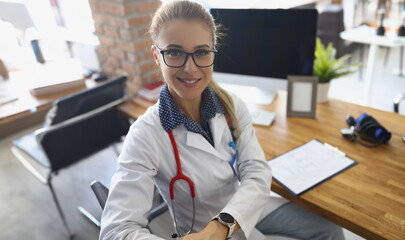 Portrait of cheerful doctor in uniform, stethoscope tool on neck, modern clinic office....