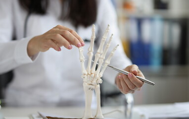 Close-up of female scientist explore human skeleton hand model, laboratory and medical anatomy...