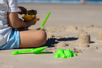 Child playing on the beach. Play in the sand during the holidays. fun with sand and beach toys.