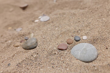 Fototapeta na wymiar Close-up of stone put in human foot shape on sand, hot summer day, coastline, sandy beach. Summertime, beachfront, nature, wildlife, digging, shore concept
