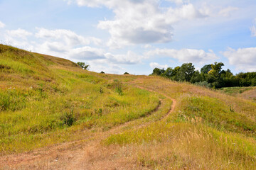 hill with dry grass and road going up copy space  