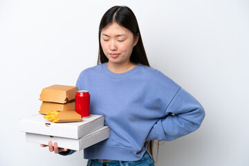 Young Chinese woman holding fast food isolated on white background suffering from backache for having made an effort