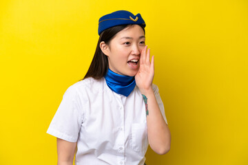 Airplane Chinese woman stewardess isolated on yellow background shouting with mouth wide open to the lateral