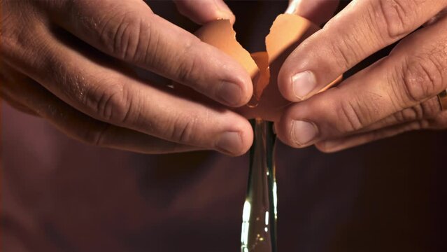 Hands of a man with a falling raw egg. Filmed on a high-speed camera at 1000 fps. High quality FullHD footage