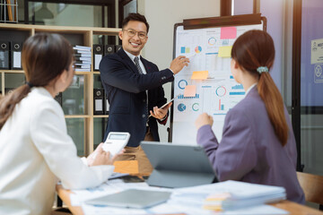 Group of Young Asian business team creative businesspeople coworker in office. Meeting Presentation for analysis graph company financial. People Work in Business Office.