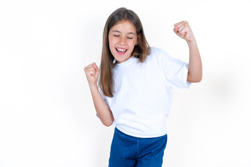 Ecstatic Beautiful little kid girl wearing white T-shirt shout loud yeah fist up raise win lottery
