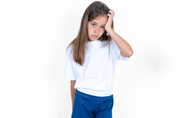 Embarrassed Beautiful kid girl wearing white T-shirt with shocked expression, expresses great...