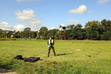 Drone pilot during unmanned aerial vehicle training. Man pilot controlling quadcopter drone with remote controller pad.