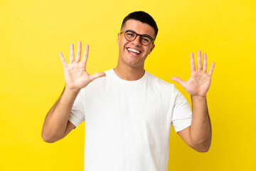 Young handsome man over isolated yellow background counting ten with fingers