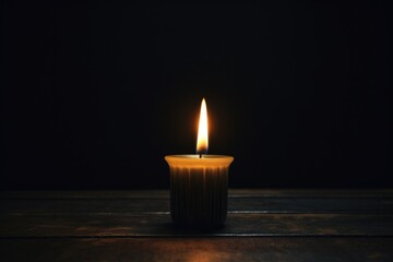 Obraz na płótnie Canvas a single candle burning in a dark room