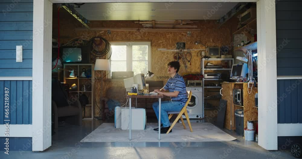 Poster caucasian male software developer programming on old desktop computer in retro garage with random ap