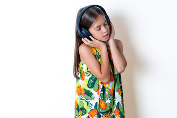 MODEL with headphones on her head, listens to music, enjoying favourite song with closed eyes, holding hands on headset.