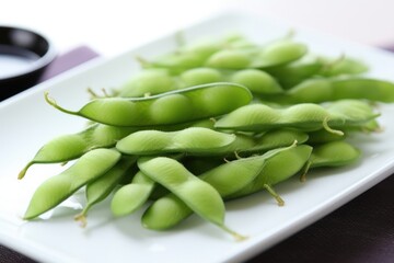 close-up of edamame pods on white plate