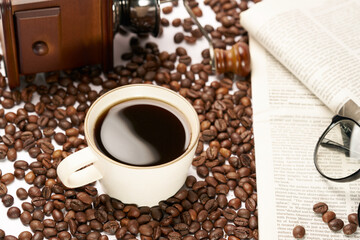 Black coffee and coffee beans on newspaper