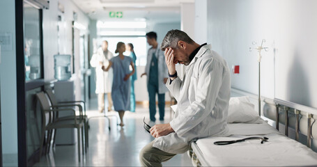 Depression, grief or fail with a mature doctor in a hospital looking unhappy for healthcare or...