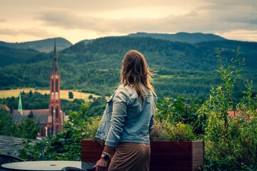 Beautiful brunette woman in brown dress and blue jeans jacket on view point in Walbrzych, Poland....