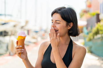 Young pretty Bulgarian woman with a cornet ice cream at outdoors with surprise and shocked facial expression