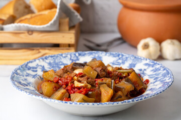 Top view of Turkish dish Guvech - baked meat with eggplant and traditionally served in earthenware pot (Turkish name; etli patlican guvec or patlican tava)