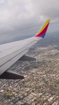 Flying over the San Fernando Valley after take off from Burbank Airport. Big passenger airplane taking off from an airport of a big city. vertical, vertical video background.