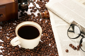 Black coffee and coffee beans on newspaper