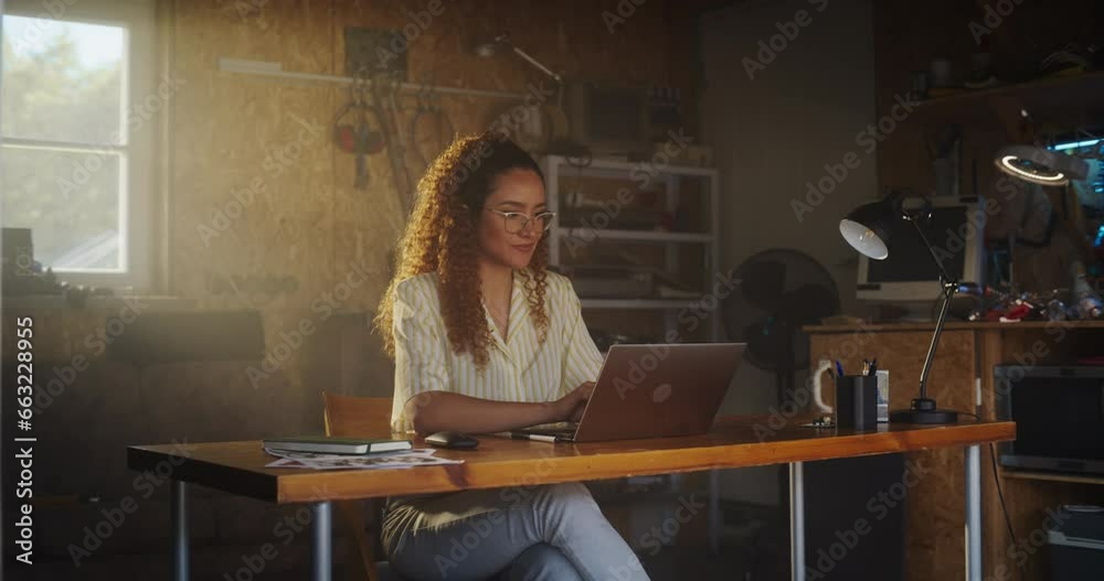 Leinwandbilder hispanic female programmer writing code on laptop computer in garage at home. woman working on innov
