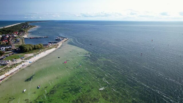 Aerial birds eye shot showing Kitesurfer on baltic sea with sandy beach during sunny day, Poland