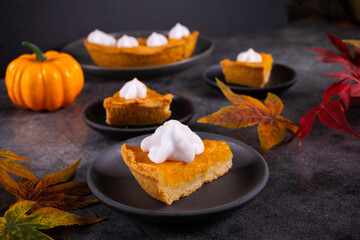 Slice of fresh baked traditional american homemade pumpkin pie decorating whipped cream for celebrating holidays
