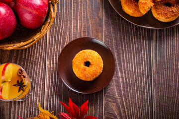 Obraz na płótnie Canvas Sweet homemade apple cider donuts with cinnamon sugar on the wooden table. Autumn food.