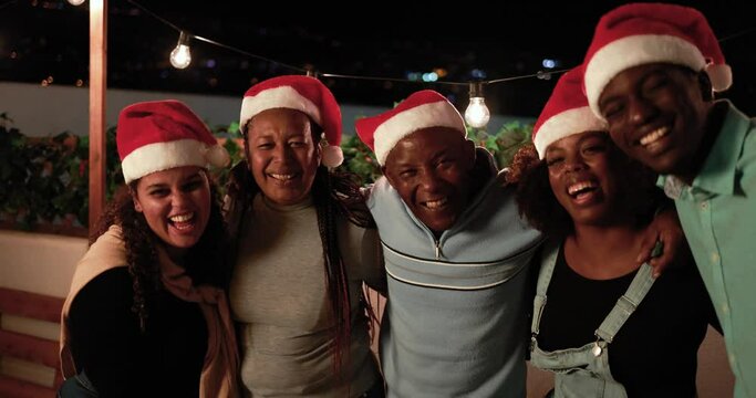 Happy african family having fun hugging each other and smiling on camera while celebrating Christmas eve together - Holiday concept