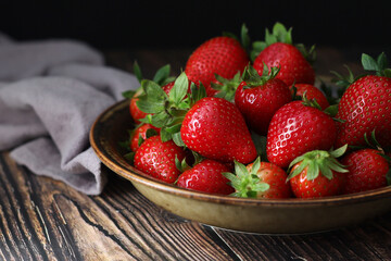 A bowl with ripe bright strawberry in rustic style