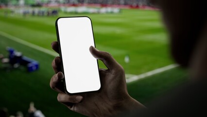 Black African-American male using phone during soccer football game, making bet