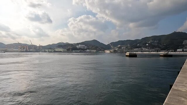 View over the harbor bay of Nagasaki on a beautiful sunny day. Showing the entire bay and hills and Waterfront Japan