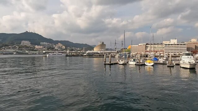 View over the habor basin of Nagasaki, Japan, opening shot showing boats and the waterfront. Japan