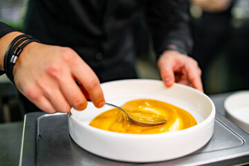 Chef cook hand cooking food with sauce at the restaurant kitchen